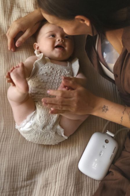 Mamá en la cama con su bebé extrayendo leche materna