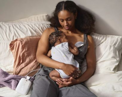 Mom on bed pumping with baby